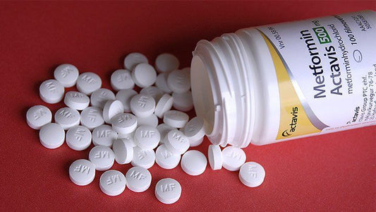 metformin bottle and pills on red background