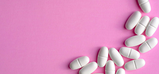 white ambien pills on pink background